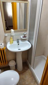 a bathroom with a sink and a shower and a toilet at Hostal Restaurante Moderno in Cistierna