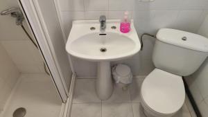 a bathroom with a white toilet and a sink at Hostal Restaurante Moderno in Cistierna +5 photos