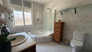 a bathroom with a tub and a sink and a toilet at Apartamento en Casa Tía María in Bueu +25 photos