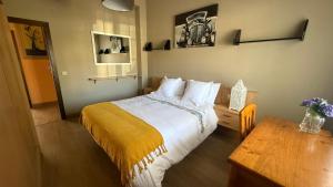 a bedroom with a bed and a wooden table at Apartamento en Casa Tía María in Bueu