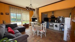 a living room with a couch and a table and a kitchen at Apartamento en Casa Tía María in Bueu