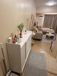 a living room with a white kitchen with a couch at The Nook at Avida Towers 2 CDO in Cagayan de Oro