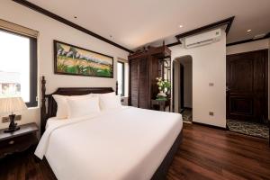 a bedroom with a large white bed and a window at Tam Coc Holiday Hotel & Spa in Ninh Binh +109 photos