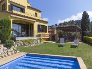 a villa with a swimming pool in front of a house at Amaya in Begur