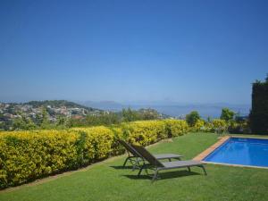 a chair sitting on the grass next to a swimming pool at Amaya in Begur