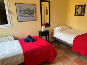a bedroom with two beds and a red blanket at Amaya in Begur +23 photos