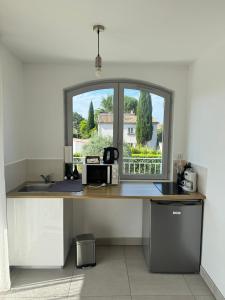 a kitchen with a counter with a sink and a window at Appartement en Luberon in Pertuis