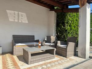a patio with wicker chairs and a table at Appartement en Luberon in Pertuis