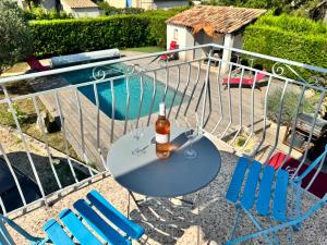 a bottle of beer sitting on a table next to chairs at Appartement en Luberon in Pertuis