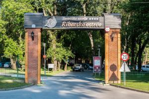 an archway with a car driving through a street at Tourist Resort Ribarsko Ostrvo in Novi Sad