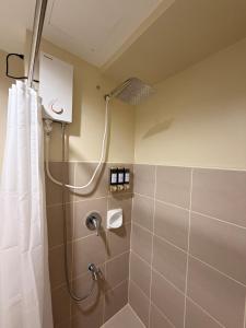 a bathroom with a shower with a shower curtain at The Nook at Avida Towers 2 CDO in Cagayan de Oro