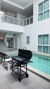 a picnic table in front of a swimming pool at The Inn10 Pool Villa Pattaya, Entire 5-9 BR, Please view photos before booking in Pattaya