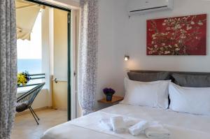 a bedroom with a white bed and a balcony at Corfu Glyfada Beach Apartment 91 in Glyfada