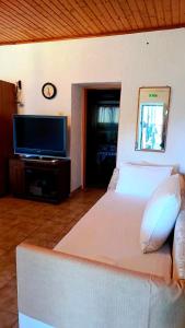 a bedroom with a large white bed and a flat screen tv at Grapes and Roses 2 in Igoumenitsa