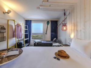 a bedroom with a bed with a hat on it at ibis styles La Rochelle Thalasso Chatelaillon in Châtelaillon-Plage