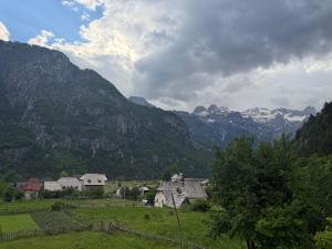 a village in a field with mountains in the background at Te Oli Theth in Theth