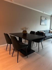 a black dining room table with chairs and a couch at Spacious apartment with 3 Bedrooms & balcony in Voss in Vossevangen