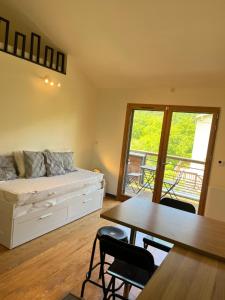 a bedroom with a bed and a table and chairs at Chalet 6 personnes ou studio 2 personnes in Ax-les-Thermes