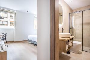 a bathroom with a sink and a toilet and a shower at Hotel Truita in Cangas del Narcea +43 photos