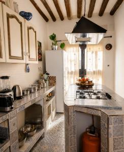 a kitchen with a stove and a refrigerator at La Bastida Del Mirador in Diezma