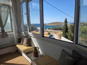 a room with large windows with a view of the ocean at Aegean Balcony in Tinos
