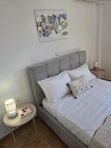 a bed with white pillows and a side table at Aegean Balcony in Tinos