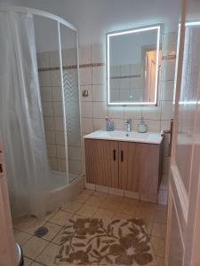 a bathroom with a sink and a shower with a mirror at Aegean Balcony in Tinos +10 photos