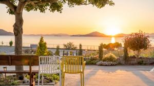 two chairs and a table with a sunset in the background at Yeosu Everyday Small Changes Pension in Yeosu