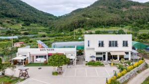 an aerial view of a building with mountains in the background at Yeosu Everyday Small Changes Pension in Yeosu