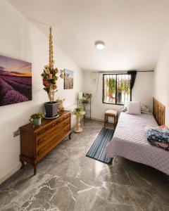a bedroom with two beds and a wooden dresser at La Bastida Del Mirador in Diezma