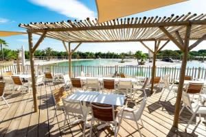 a deck with tables and chairs and a pool at Chalet La Dragonniere in Vias