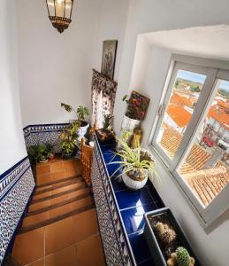 a room with a staircase with potted plants and a window at La Bastida Del Mirador in Diezma +6 photos