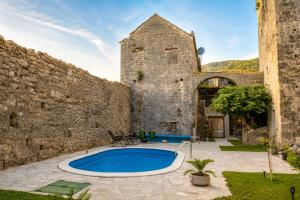 an old stone building with a swimming pool in a yard at Villa Bilja Historic Stone Castle in Trebinje