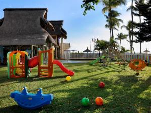 a playground with toys on the grass in front of a house at Sofitel Mauritius L'Imperial Resort & Spa in Flic-en-Flac