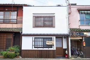 a white building with a sign on the window at Kyoyado Hakuto in Kyoto