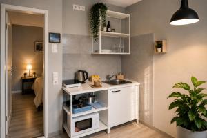 a small kitchen with a sink and a microwave at Modern Living Apartment Hotel in Nuremberg