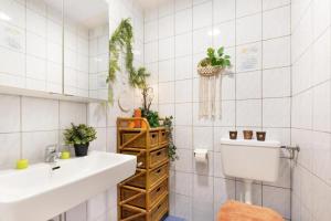 a white tiled bathroom with a sink and a toilet at Ferienwohnung Bonny in Schlitters +36 photos