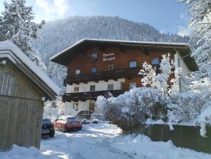 a large building in the snow with cars parked in front at Ferienwohnung Bonny in Schlitters