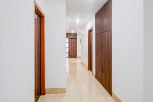 a hallway with wooden cabinets and a tile floor at Super Collection O Sixmile Guwahati Formerly Hotel Gangotri in Guwahati