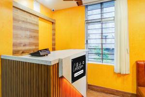 an office with yellow walls and a sign on a counter at Super Collection O Sixmile Guwahati Formerly Hotel Gangotri in Guwahati