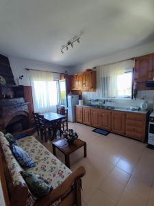 a living room with a couch and a kitchen with a table at Μπλέ σπίτι in Karavostamo