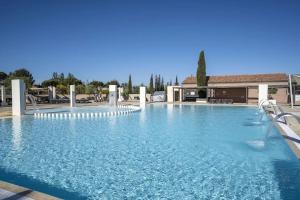 a large swimming pool with blue water at Chalet La Dragonniere in Vias