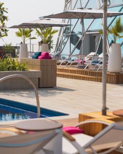 a swimming pool with lounge chairs and a boat at Andaz Capital Gate Abu Dhabi, By Hyatt in Abu Dhabi