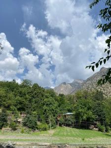 a view of the mountains from a field at Kalash Echo Lodge in Chitral