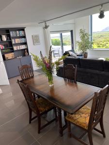 a living room with a wooden table with flowers on it at Leac na Cille in Dingle