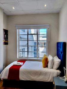 a bedroom with a large bed with a window at Pepper Korrel - Paarl - Self Catering Apartment in Paarl