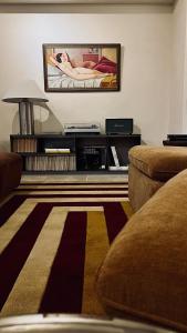 a living room with a couch and a tv on the wall at VILLA LORES Adults Only Retreat near Sanxenxo & O Grove in Lores