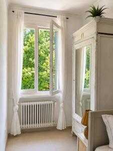 a white room with two windows and a radiator at Garden Lodge by Veneto Villa in Albignasego