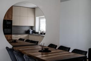 a dining room with a table with chairs and a mirror at Sodyba Biruta in Tautrimai