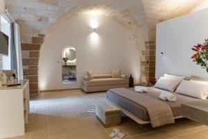 a bedroom with a bed and a couch in a room at "Corte Tedesco" - Apulian Luxury Suites in Brindisi